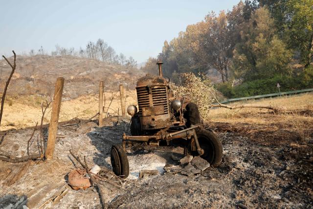 A picture taken on August 17, 2026 shows a burnt tractor in Santa Cruz de la Seros, in the Spanish northeastern province of Aragon amid a wildfire that burnt 16,600 hectares. A Spanish soldier died on August 16, 2026 while helping efforts to extinguish a major wildfire in the northeastern region of Aragon. The fire that has raged for a week threatened a 1,000-year-old monastery, sheltering the bones of the first Aragonese kings, founders of the Kingdom of Aragon. (Photo by Oscar DEL POZO / AFP)