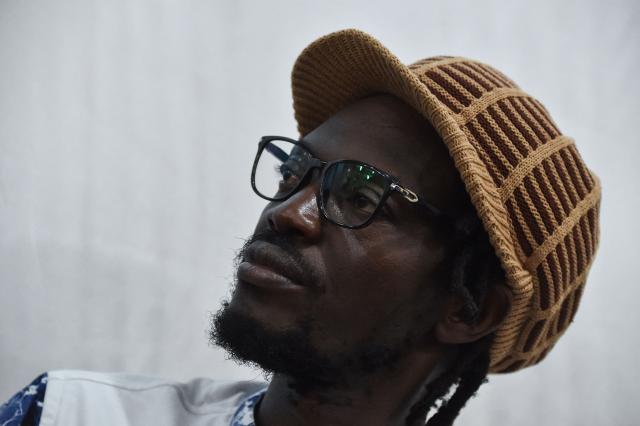 (FILES) Malian activist Mohamed Youssouf Bathily also known as Ras Bath takes part in a press conference organised by opposition leaders at the Maison de la Presse (Press House) in Bamako on August 1, 2018. A Malian court sentenced on Monday a prominent journalist and an influencer, who had both criticised the ruling junta, to seven years in jail, an AFP journalist saw. 
Television and radio commentator Mohamed Youssouf Bathily -- alias Ras Bath -- was convicted by the court in Bamako of criminal conspiracy and discrediting the state, alongside Rokia Doumbia, a noted campaigner known online as "Rose, the cost of living". (Photo by ISSOUF SANOGO / AFP)