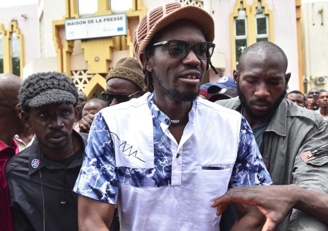 (FILES) Malian activist Mohamed Youssouf Bathily also known as Ras Bath leaves the Maison de la Presse (Press House) in Bamako on August 1, 2018 after taking part in a press conference organised by opposition leaders. A Malian court sentenced on Monday a prominent journalist and an influencer, who had both criticised the ruling junta, to seven years in jail, an AFP journalist saw. 
Television and radio commentator Mohamed Youssouf Bathily -- alias Ras Bath -- was convicted by the court in Bamako of criminal conspiracy and discrediting the state, alongside Rokia Doumbia, a noted campaigner known online as "Rose, the cost of living". (Photo by ISSOUF SANOGO / AFP)