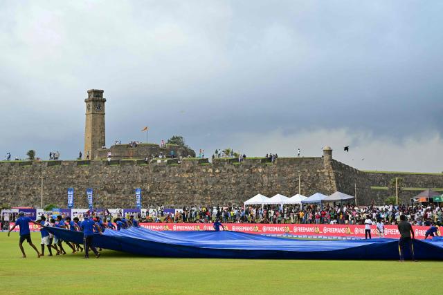 Ground staff cover the pitch at the end of third day of the first Test cricket match between Sri Lanka and India at the Galle International Stadium in Galle on August 17, 2026. (Photo by Ishara S. KODIKARA / AFP)