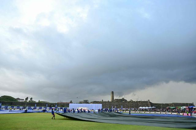 Ground staff cover the pitch at the end of third day of the first Test cricket match between Sri Lanka and India at the Galle International Stadium in Galle on August 17, 2026. (Photo by Ishara S. KODIKARA / AFP)