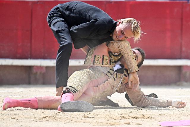 French matador Lalo De Maria (L) helps French novillero (young matador) Victor (R) after he was knocked down during his bullfight as part of the Feria in Beziers, southern France on August 16, 2026. (Photo by Gabriel BOUYS / AFP)