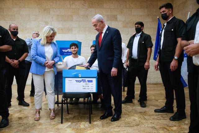 TOPSHOT - Israeli Prime Minister Benjamin Netanyahu, (C-R), and his wife, Sara, (C-L) cast their ballot at his party Likud's main polling station during primary elections ahead of Israels general election in October in Jerusalem on August 17, 2026. The Likud, the historic party of the Israeli right and the political base of Prime Minister Benjamin Netanyahu, held primaries on August 17 to determine its slate of candidates for the general election on October 27. Likud is projected to win around 22-23 of the 120 seats in the Knesset, Israel's parliament, according to the latest polls -- a dramatic drop from the 32 seats it won in the 2022 election. (Photo by Ohad Zwigenberg / POOL / AFP)