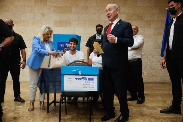 Israeli Prime Minister Benjamin Netanyahu, (C-R), and his wife, Sara, (C-L) cast their ballot at his party Likud's main polling station during primary elections ahead of Israels general election in October in Jerusalem on August 17, 2026. The Likud, the historic party of the Israeli right and the political base of Prime Minister Benjamin Netanyahu, held primaries on August 17 to determine its slate of candidates for the general election on October 27. Likud is projected to win around 22-23 of the 120 seats in the Knesset, Israel's parliament, according to the latest polls -- a dramatic drop from the 32 seats it won in the 2022 election. (Photo by Ohad Zwigenberg / POOL / AFP)