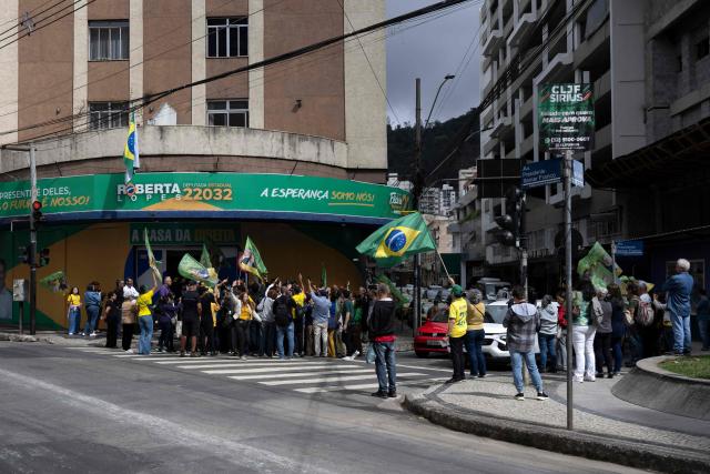 Brazilian lawmaker Nikolas Ferreira (unseen) greets supporters outside a Liberal Party (PL) office in Juiz de Fora, Minas Gerais state, Brazil, on August 17, 2026, after organizers cancelled presidential candidate Flavio Bolsonaro's event due to weather conditions. (Photo by Pablo PORCIUNCULA / AFP)
