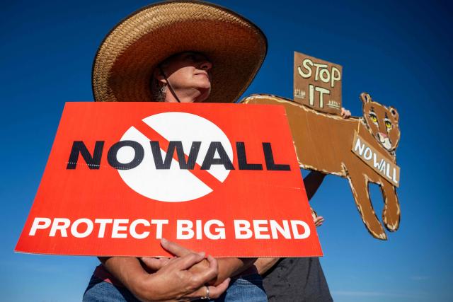 (FILES) A woman hold's a sign to protest the plans by US President Donald Trump's administration to build a section of the border wall at the Big Bend National Park in Study Butte, Texas, on August 15, 2026. Trump's administration said August 17, 2026 it had paused construction on a $1.7 billion border project at Big Bend National Park in Texas that has faced fierce local opposition across party lines. (Photo by RONALDO SCHEMIDT / AFP)