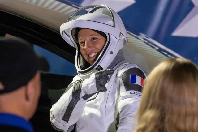 (FILES) ESA (European Space Agency) astronaut Sophie Adenot points to the French flag on her shoulder as she prepares to travel to the SpaceX Falcon 9 rocket with the company's Dragon spacecraft at Space Launch Complex 40 for the Crew-12 mission at Cape Canaveral Space Force Station in Florida, on February 13, 2026. Adenot, who is currently staying on the International Space Station (ISS), will perform her first spacewalk on Tuesday, August 18, 2026, accompanied by American Anil Menon, a first for a French woman. (Photo by Jim WATSON / AFP)