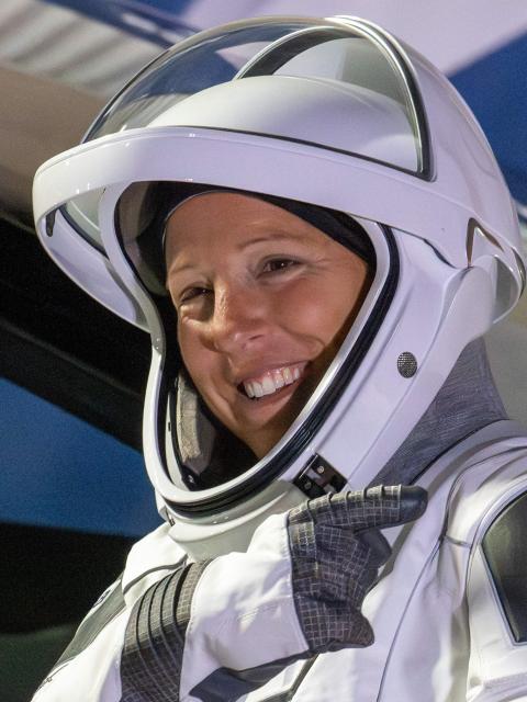 (FILES) ESA (European Space Agency) astronaut Sophie Adenot points to the French flag on her shoulder as she prepares to travel to the SpaceX Falcon 9 rocket with the company's Dragon spacecraft at Space Launch Complex 40 for the Crew-12 mission at Cape Canaveral Space Force Station in Florida, on February 13, 2026. Adenot, who is currently staying on the International Space Station (ISS), will perform her first spacewalk on Tuesday, August 18, 2026, accompanied by American Anil Menon, a first for a French woman. (Photo by Jim WATSON / AFP)