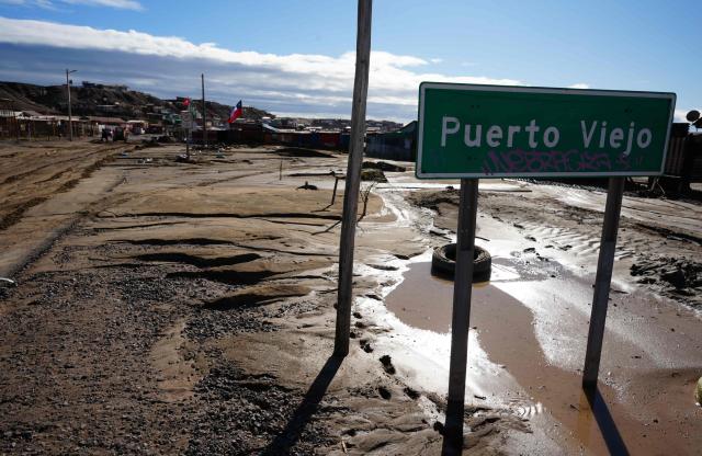 A Puerto Viejo sign is pictured after a mudslide following heavy rains in Puerto Viejo, Caldera commune, Atacama region, Chile on August 17, 2026. (Photo by Patricio BANDA / AFP)