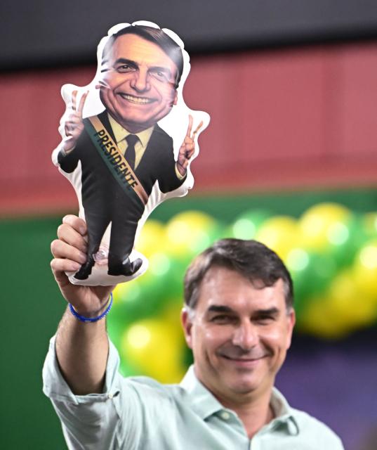 Senator and right-wing presidential candidate Flavio Bolsonaro holds an inflatable of his father, convicted former President Jair Bolsonaro, during a rally at Mackenzie Esporte Clube in Belo Horizonte, Brazil on August 17, 2026. Brazilians will go to the polls next October 4 once again deeply polarized and under the shadow of US President Donald Trump, who has backed conservative candidates in recent elections in Latin America. (Photo by Gledston Tavares / AFP)