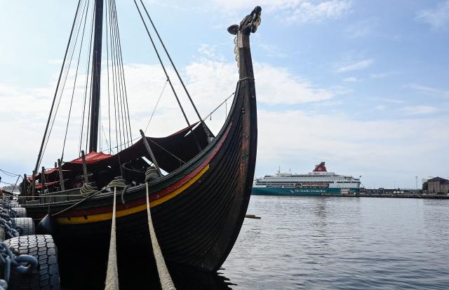 The Draken Harald Harfagre (the ship used in the movie the Odyssey) is docked outside Oslo Opera in the Norwegian capital on August 14, 2026. Ulysses on a Viking ship? Two millennia separate the two worlds. Yet it’s precisely on board such a vessel that Christopher Nolan has the Greek hero sail in “The Odyssey,” a deliberate anachronism in the service of realism. With its tar-soaked ropes, creaking oak deck, and fifty slender spruce oars, the Draken Harald Hеrfagre, the largest modern replica of a Viking ship, has, for the duration of a film shoot, swapped the fantasy of Scandinavian sagas for that of Greek mythology. (Photo by Jonathan KLEIN / AFP)