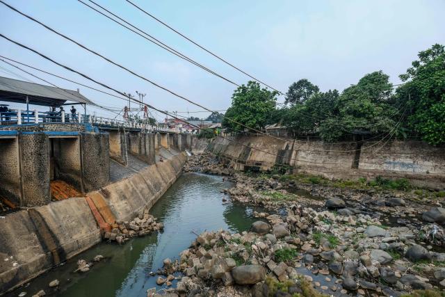 This picture taken on August 6, 2026 shows rocks surfacing at the bottom of a river as the water level drops in part due to the impact of El Nino, at the Katulampa floodgate in Bogor, West Java. Indonesia believes cloud seeding can help it tackle a wildfire season that experts say is on track to be among the worst in years, driven by a strong El Nino. (Photo by BAY ISMOYO / AFP)