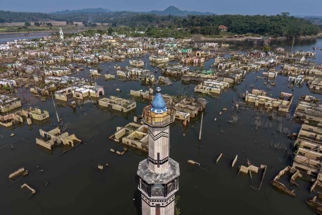 (FILES) An aerial view taken on July 30, 2026 shows a mosque and surrounding buildings in Somang village in Lebak in Indonesia's western Banten province, which was deliberately flooded to make way for the construction and filling of the Karian Dam that opened in 2023 and has now re-emerged due to the El Nino-driven drought. Indonesia believes cloud seeding can help it tackle a wildfire season that experts say is on track to be among the worst in years, driven by a strong El Nino. (Photo by BAY ISMOYO / AFP)