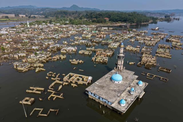 (FILES) An aerial view taken on July 30, 2026 shows a mosque and surrounding buildings in Somang village in Lebak in Indonesia's western Banten province, which was deliberately flooded to make way for the construction and filling of the Karian Dam that opened in 2023 and has now re-emerged due to the El Nino-driven drought. Indonesia believes cloud seeding can help it tackle a wildfire season that experts say is on track to be among the worst in years, driven by a strong El Nino. (Photo by BAY ISMOYO / AFP)