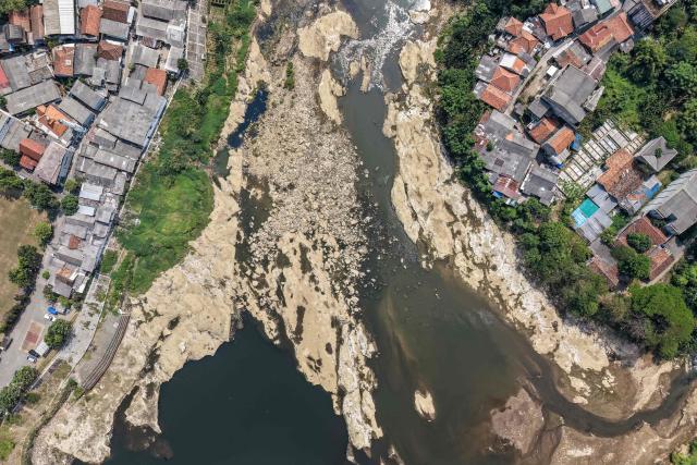 (FILES) This aerial picture shows rocks surfacing at the bottom of a river in Tangerang, Banten province, on July 17, 2026, as the water level drops in part due to the impact of El Nino, which has brought a prolonged dry season and triggered extreme drought, threatening food security in various regions of Indonesia. Indonesia believes cloud seeding can help it tackle a wildfire season that experts say is on track to be among the worst in years, driven by a strong El Nino. (Photo by BAY ISMOYO / AFP)