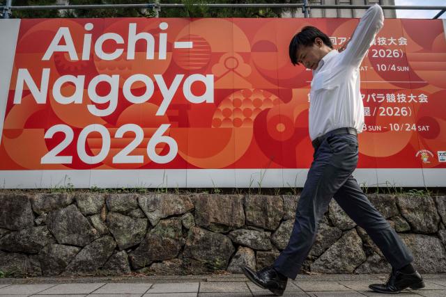 (FILES) This picture taken on September 8, 2025 shows a man walking past an advertisement for the 2026 Asian Games in Nagoya, Aichi prefecture. The Asian Games begin in Japan on September 19, 2026 featuring teenage prodigies, more athletes than the Olympics and a cruise ship that will house competitors in the middle of typhoon season. (Photo by Yuichi YAMAZAKI / AFP)