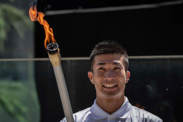 Japanese sprinter Yoshihide Kiryu takes part in the torch lighting ceremony for the 2026 Asian Games, outside the National Stadium in Tokyo on August 18, 2026. About 15,000 competitors and officials are expected at the event, which takes place in Nagoya and the wider Aichi area from September 19 to October 4. (Photo by Yuichi YAMAZAKI / AFP)