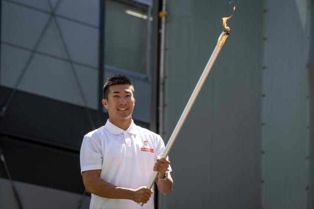 Japanese sprinter Yoshihide Kiryu takes part in the torch lighting ceremony for the 2026 Asian Games, outside the National Stadium in Tokyo on August 18, 2026. About 15,000 competitors and officials are expected at the event, which takes place in Nagoya and the wider Aichi area from September 19 to October 4. (Photo by Yuichi YAMAZAKI / AFP)