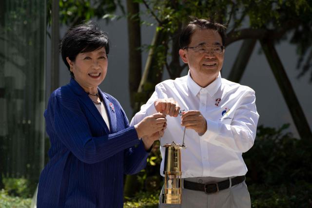 Governor of Aichi Prefecture Hideaki Omura (R) and Governor of Tokyo Yuriko Koike take part in the torch lighting ceremony for the 2026 Asian Games, outside the National Stadium in Tokyo on August 18, 2026. About 15,000 competitors and officials are expected at the event, which takes place in Nagoya and the wider Aichi area from September 19 to October 4. (Photo by Yuichi YAMAZAKI / AFP)