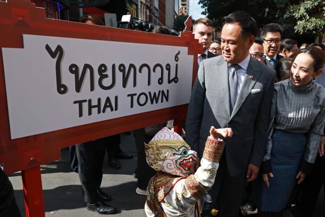Thailand's Prime Minister Anutin Charnvirakul (C) and his wife Thananon Niramit (R) react as they meet members of the public during a visit to Thaitown in Sydney on August 18, 2026. The Thai Prime Minister is on a three-day official visit to Australia. (Photo by DAVID GRAY / AFP)