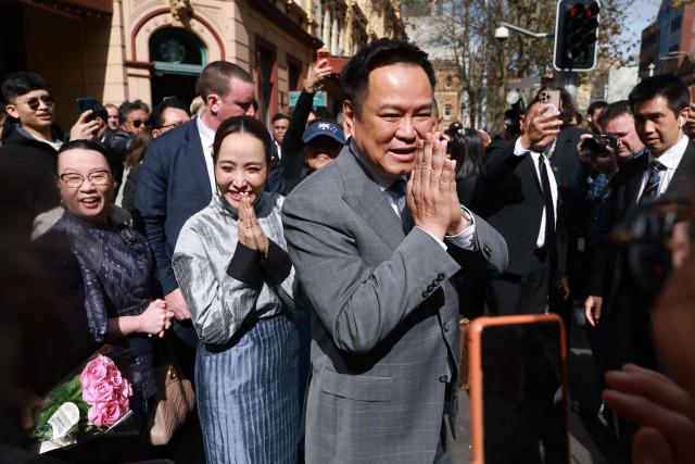 Thailand's Prime Minister Anutin Charnvirakul (C) and his wife Thananon Niramit (L) react to members of the public as they visit Thaitown in Sydney on August 18, 2026. The Thai Prime Minister is on a three-day official visit to Australia. (Photo by DAVID GRAY / AFP)