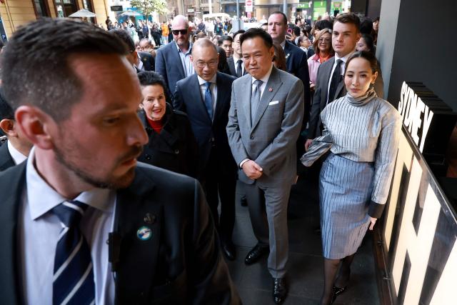 Thailand's Prime Minister Anutin Charnvirakul (C) and his wife Thananon Niramit (R) walk with officials as they visit Thaitown in Sydney on August 18, 2026. The Thai Prime Minister is on a three-day official visit to Australia. (Photo by DAVID GRAY / AFP)