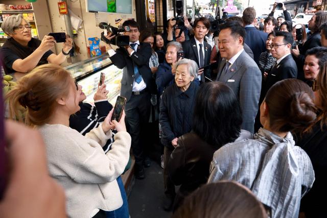 Thailand's Prime Minister Anutin Charnvirakul (C) reacts as he poses for a photograph during a visit to Thaitown in Sydney on August 18, 2026. The Thai Prime Minister is on a three-day official visit to Australia. (Photo by DAVID GRAY / AFP)