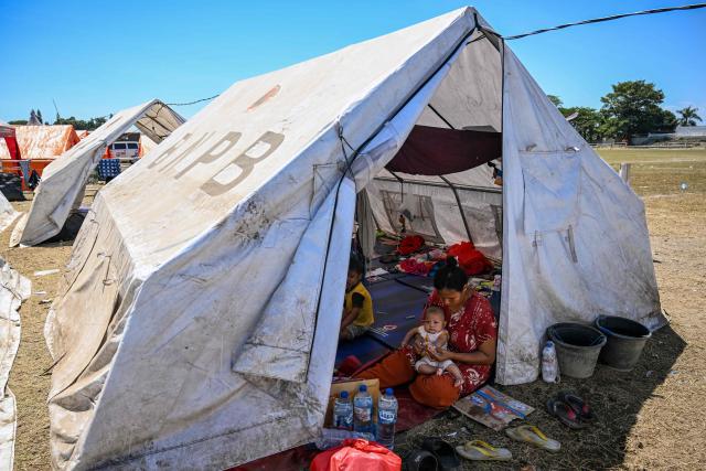 Villagers shelter in a tent in Maumere, East Nusa Tenggara, on August 18, 2026, following a 7.7-magnitude earthquake that struck Indonesia's Flores island on August 15. Thousands of people displaced by a powerful earthquake in eastern Indonesia awaited much-needed aid on August 17 as they camped out at schools, police stations and government offices, with many stuck outside. (Photo by JUNI KRISWANTO / AFP)