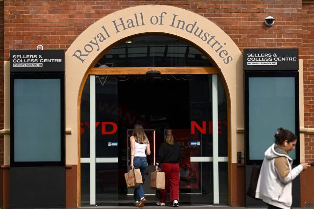 People walk past the Sydney Swans' headquarters building in Sydney on August 18, 2026. Top Australian Rules side the Sydney Swans said it was "extremely shocked and disappointed" on August 17 after several unidentified players were involved in an "alleged incident" in Melbourne. (Photo by Saeed KHAN / AFP)