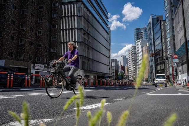 A man rides a bicycle along a road in Tokyo on August 18 ,2026. (Photo by Yuichi YAMAZAKI / AFP)