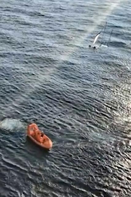 This video grab shows a lifeboat (L) approaching a drifting sailboat, filmed from a ferry off the coast of French island of Ile-d'Yeu, western Franc on August 17, 2026 as search operations are underway to try to locate its occupants. The alarm was raised by a passenger on a Brittany Ferries vessel, travelling between Portsmouth (UK) and Bilbao (Spain), who "spotted a drifting sailboat." (Photo by John WEAVER / AFP)