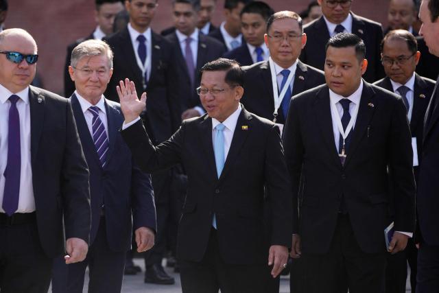 Myanmar's President Min Aung Hlaing (C) waves as he walks with officials while he attends a wreath-laying ceremony at the Tomb of the Unknown Soldier near the Kremlin wall in Moscow on August 18, 2026. (Photo by Pavel Bednyakov / POOL / AFP)