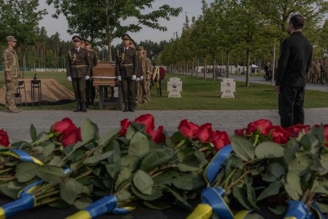Ukraine's President Volodymyr Zelensky (R) looks at servicemen of the Ukrainian Honour Guard carrying thz coffin bearing the repatriated remains of Yevhen Konovalets, leader of the Organisation of Ukrainian Nationalists (OUN), who was killed by a Soviet agent in 1938, during his reburial ceremony at the National Military Memorial Cemetery near Kyiv on August 18, 2026, amid the Russian invasion of Ukraine. (Photo by Roman PILIPEY / AFP)