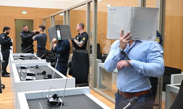 Three Ukrainian defendants, who are accused for plotting to send exploding parcels from Germany to Ukraine on the orders of a Russian intelligence service, wait for the verdict of their trial in the courtroom of the higher regional court in Stuttgart-Stammheim, southern Germany on on August 18, 2026. (Photo by THOMAS KIENZLE / AFP)