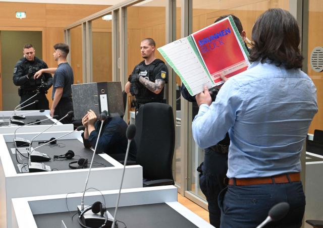 Three Ukrainian defendants, who are accused for plotting to send exploding parcels from Germany to Ukraine on the orders of a Russian intelligence service, wait for the verdict of their trial in the courtroom of the higher regional court in Stuttgart-Stammheim, southern Germany on on August 18, 2026. (Photo by THOMAS KIENZLE / AFP)