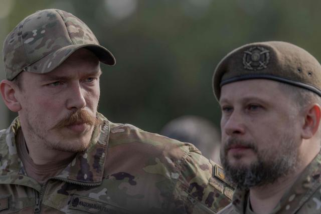 Brigadier General Andriy Biletsky (R) of the Third Army Corps of the Ukrainian Armed Forces and Brigadier General Denys Prokopenko, Commander of the 1st Corps of the National Guard of Ukraine “Azov” attend the reburial ceremony of the repatriated remains of Yevhen Konovalets, leader of the Organisation of Ukrainian Nationalists (OUN), who was killed by a Soviet agent in 1938, at the National Military Memorial Cemetery near Kyiv on August 18, 2026, amid the Russian invasion of Ukraine. (Photo by Roman PILIPEY / AFP)