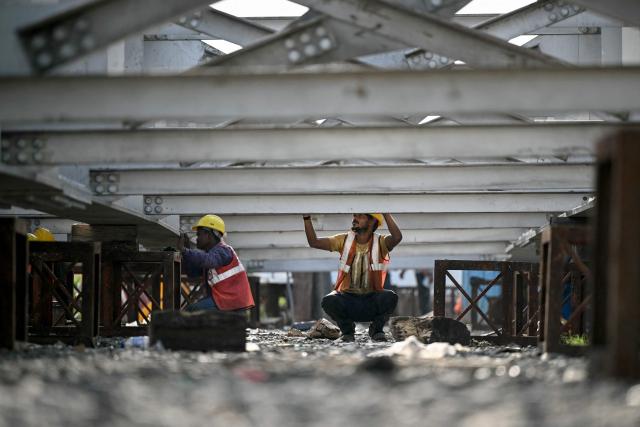 Labourers work at a construction site of the 'Chennai Metro Rail' project in Chennai on August 18, 2026. (Photo by R. Satish BABU / AFP)