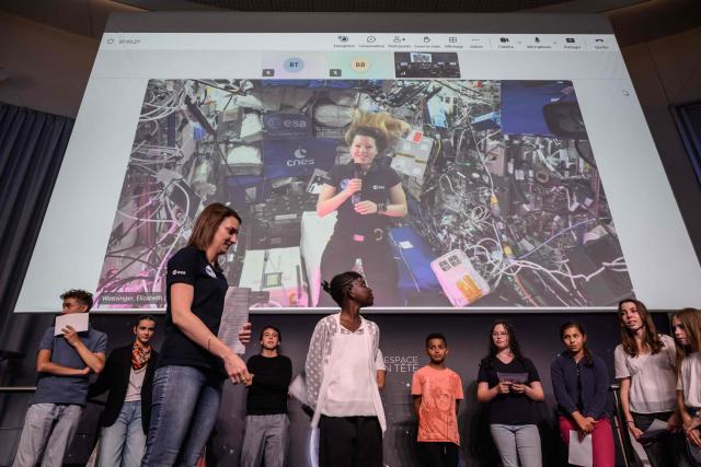 (FILES) French astronaut Sophie Adenot speaks to children from the International Space Station during a video call, at the Centre Nationale d'Etudes Spatiale (CNES), in Toulouse on June 3, 2026. Sophie Adenot became the first French female astronaut to venture outside the International Space Station for a spacewalk on August 18, 2026, accompanied by American astronaut Anil Menon. President Emmanuel Macron hailed Sophie Adenot's spacewalk, describing the event as a source of "French pride" and seeing the astronaut as "the face of all possibilities." (Photo by Ed JONES / AFP)