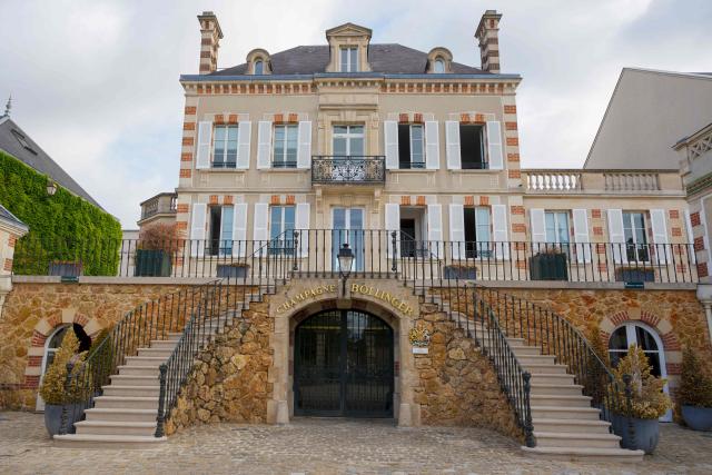 This photograph shows a “Champagne Bollinger” sign on a building facade at the Bollinger Champagne House’s vineyard in Ay, northeastern France, on August 18, 2026. (Photo by Jean-Christophe VERHAEGEN / AFP)