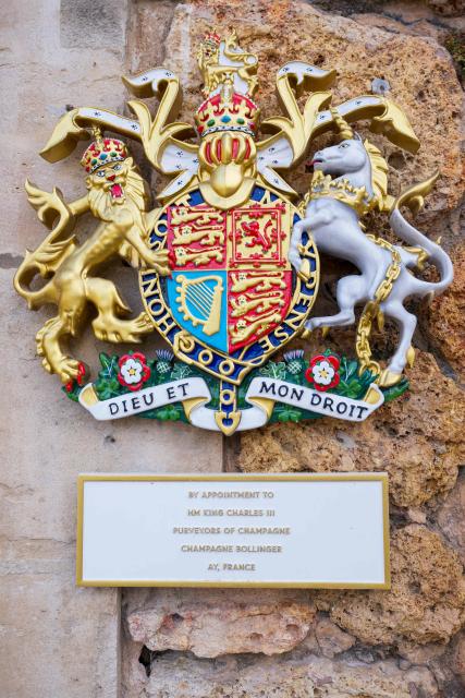 This photograph shows the coat of arms of the British Crown, reading « By appointment to HM King Charles III - Purveyors of champagne - Champagne Bollinger - Ay, France » at the Bollinger Champagne House’s vineyard in Ay, northeastern France, on August 18, 2026. (Photo by Jean-Christophe VERHAEGEN / AFP)
