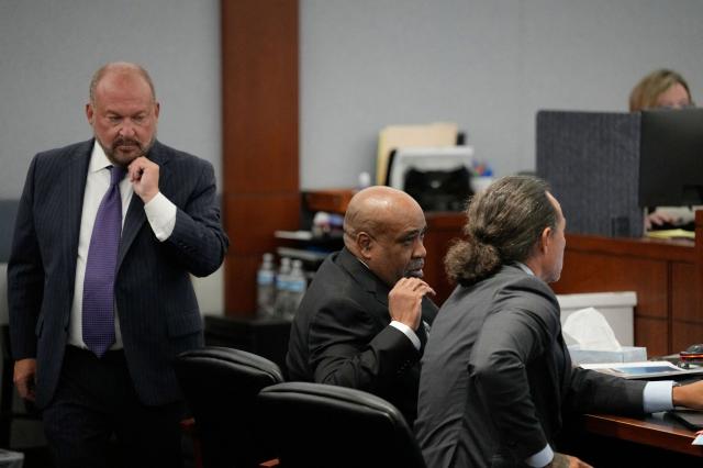 Chief Deputy District Attorney Marc DiGiacomo (L) walks behind Duane Davis (C) and defense attorney Michael Sanft (R) during Davis murder trial related to the 1996 killing of rapper Tupac Shakur, at Clark County District Court Regional Justice Center in Las Vegas, on August 18, 2026. The trial of the former gang leader accused of orchestrating the murder of rapper Tupac Shakur began on August 10, 30 years after one of America's most high-profile unresolved killings. The proceedings, expected to last a month, will likely not make clear who fired the shots that killed the California hip-hop legend on the night of September 7, 1996, while he was in Las Vegas to see a Mike Tyson boxing match. (Photo by John Locher / POOL / AFP)