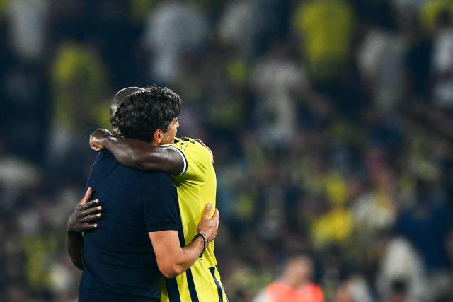Fenerbahce's Belgian forward #09 Romelu Lukaku (R) embraces Lyon's Portuguese head coach Paulo Fonseca at the end of the UEFA Champions League qualifying playoff - first leg football match between Fenerbahce SK and Olympique Lyonnais (OL) at the Sukru Saracoglu Stadium in Istanbul on August 18, 2026. (Photo by YASIN AKGUL / AFP)
