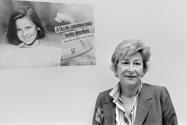 (FILES) Yvette Roudy, junior minister for Women's Rights, poses in Paris on April 6, 1984, in front of a poster which reads as "Today, occupations have no sex" and "School, let's guide ourselves in every direction", from the advertising campaign launched by the Ministry for Women's Rights, in favor of equality between men and women at school and in the professional sphere. Yvette Roudy, who served as the first Minister of Women's Rights between 1981 and 1986, died on August 18, 2026 in Cabestany (Pyrénées-Orientales) at the age of 97, her nephew Jean-Pierre Saldou told AFP. (Photo by Julien CASSAGNE / AFP)