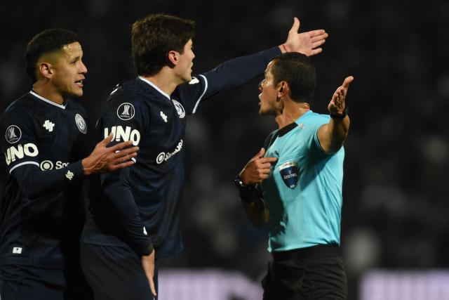 Independiente Rivadavia's Paraguayan forward #9 Alex Arce and defender #42 Sheyko Studer argue with Colombian referee Andres Rojas for not awarding them an alleged penalty during the second leg of the Copa Libertadores round of 16 football match between Argentina's Independiente Rivadavia and Brazil's Fluminense at the Malvinas Argentinas stadium in Mendoza, Argentina, on August 18, 2026. (Photo by Andres LARROVERE / AFP)