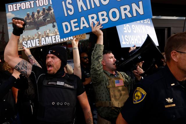 Far-right US activist Jake Lang (R) speaks into a megaphone during an anti-Muslim demonstration he organized called the "Christian Crusade March" in Dearborn, Michigan, on August 18, 2026. (Photo by JEFF KOWALSKY / AFP)