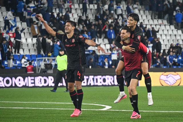 (L to R) Estudiantes' defender #04 Santiago Nunez, midfielder #07 Jose Ernesto Sosa, and forward #32 Joaquin Correa celebrate after winning the second leg of the Copa Libertadores round of 16 football match between Chile's Universidad Catolica and Argentina's Estudiantes de La Plata at the Claro Arena stadium in Santiago, on August 18, 2026. (Photo by RODRIGO ARANGUA / AFP)