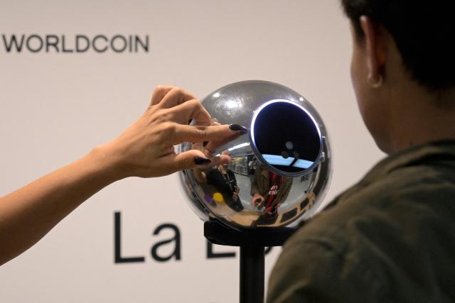 (FILES) A man has his iris scanned with an orb, a biometric data scanning device, in exchange for the Worldcoin cryptocurrency in Buenos Aires on March 22, 2024. Amnesty International on August 18, 2026 denounced the growing use of surveillance technologies by Argentine President Javier Milei's government against his critics. In a report entitled "Sensing the surveillance state," Amnesty said the creation of databases of protesters, the monitoring of their social media and the use of facial recognition technology was stifling dissent. (Photo by JUAN MABROMATA / AFP)