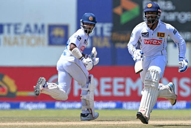 Sri Lanka's Sonal Dinusha (L) and captain Dhananjaya de Silva (R) run between the wickets during the fifth day of the first Test cricket match between Sri Lanka and India at the Galle International Stadium in Galle on August 19, 2026. (Photo by Ishara S. KODIKARA / AFP)