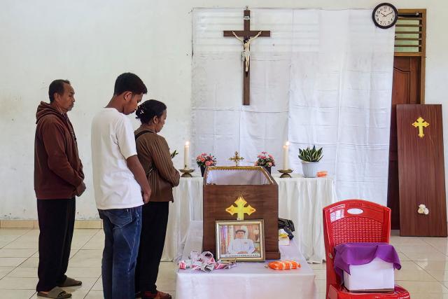 Relatives pray for Leonardus Noprianto Waku, a victim of the Flores earthquake, as it lies in state at the Chapel of St. Peter's Major Seminary Ritapiret in Maumere, East Nusa Tenggara on August 19, 2026, after the victim had previously received treatment at TC Hillers General Hospital, in Maumere, for bone fractures sustained after jumping from the 3rd floor when the earthquake occurred on August 15. (Photo by ARNOLD WELIANTO / AFP)