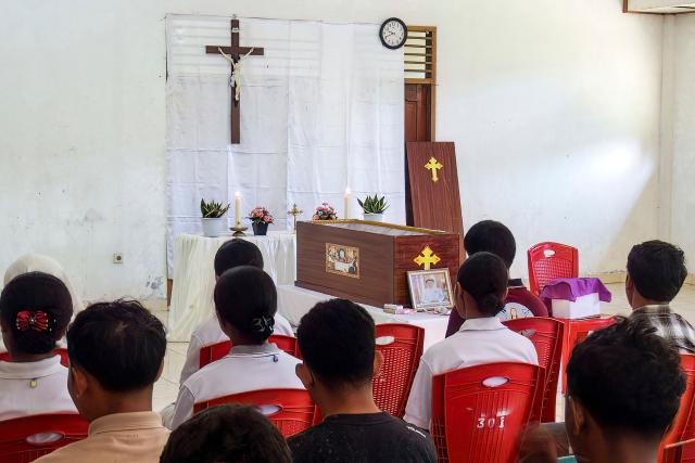 Relatives pray for Leonardus Noprianto Waku, a victim of the Flores earthquake, as it lies in state at the Chapel of St. Peter's Major Seminary Ritapiret in Maumere, East Nusa Tenggara on August 19, 2026, after the victim had previously received treatment at TC Hillers General Hospital, in Maumere, for bone fractures sustained after jumping from the 3rd floor when the earthquake occurred on August 15. (Photo by ARNOLD WELIANTO / AFP)